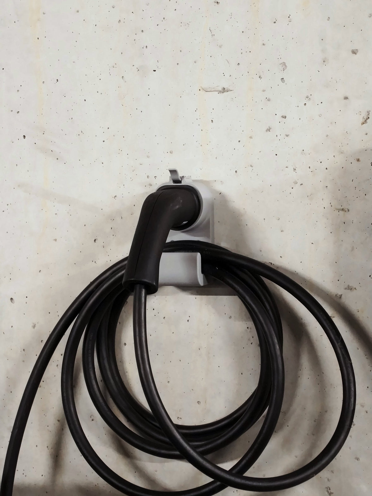 Kabelhalter Kompakt Gerade mit Ladekabel an der Betonwand